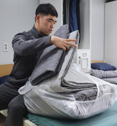 국방부는 육군과 해병대 병사들이 생활관에서 침구로 사용하던 모포 이불을 올해 상용 이불로 전면 대체했다고 17일 밝혔다. 한 장병이 전문업체에 의해 세탁된 상용 이불을 확인하고 있다. 국방부 제공