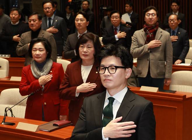 한동훈 법무부 장관과 국민의힘 의원들이 지난 6일 국회 예결위회의장에서 열린 국민의힘 정책의원총회에서 국민의례를 하고 있다. ⓒ연합뉴스