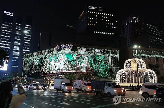 서울 명동을 찾은 시민들이 신세계백화점 본점 외벽에 설치된 미디어 파사드를 촬영하고 있다. 연합뉴스 제공