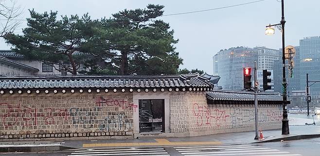 지난 16일 서울 종로구 국립고궁박물관 방향 경복궁 서쪽 담장에 붉은색과 푸른색 스프레이로 ‘영화공짜’라고 쓴 낙서가 적혀있다. 연합뉴스