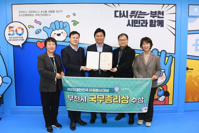 조용익 부천시장(가운데)이 대한민국 자원봉사대상 국무총리 표창을 받고 환하게 웃고 있다. 사진 제공 = 부천시