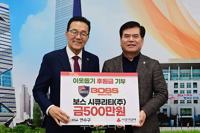 보스시큐리티(주) 공병석 대표(오른쪽)가  이재호 연수구청장에게 이웃돕기 후원금을 기부하고 기념 촬영하고 있다.[사진=연수구]