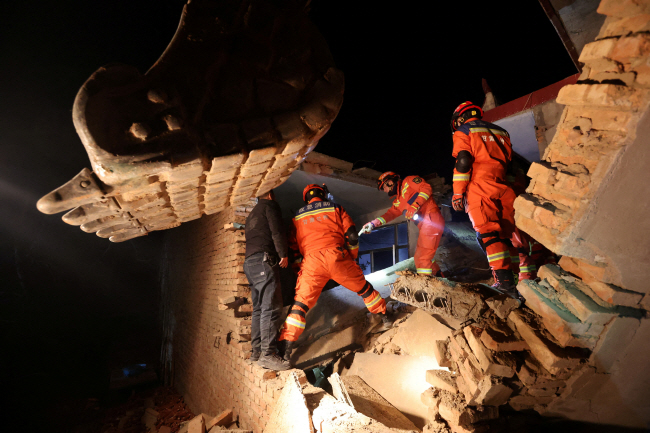 생존자 찾는 구조대원… 규모 6.2의 지진이 발생한 중국 간쑤성 린샤주 지스산현에서 19일 구조대원들이 생존자 구출을 위해 무너진 건물 잔해 속을 살피고 있다.    로이터 연합뉴스