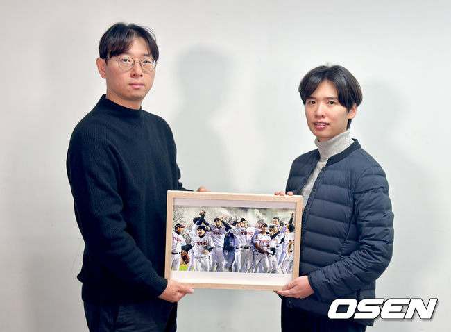 한국스포츠사진기자회 지형준 회장(왼쪽)과 '올해의 야구 보도사진상'을 촬영한 OSEN 조은정 기자가 수상작과 함께 기념 포즈를 취하고 있다. <사진제공=스포츠사진기자회>