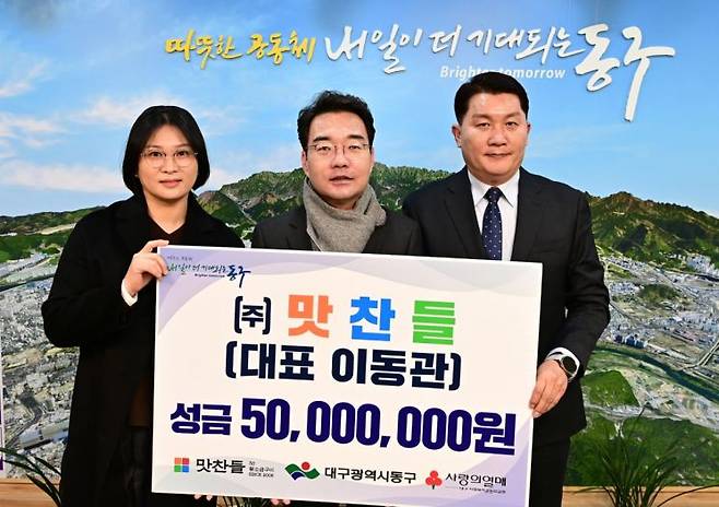 맛찬들 이동관 대표(오른쪽)가 성금 5000만원을 기탁한 뒤 윤석준 대구 동구청장(중앙)과 기념촬영을 하고 있다.