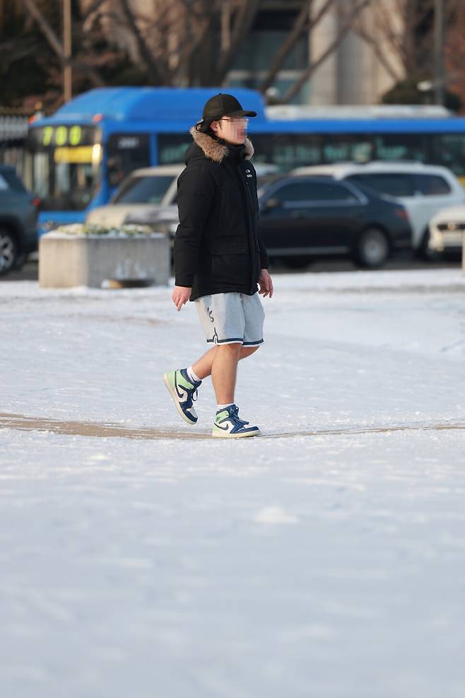 20일 오전 전날 내린 눈 사이로 반바지를 입은 한 시민이 걸어가고 있다. 김혜윤 기자