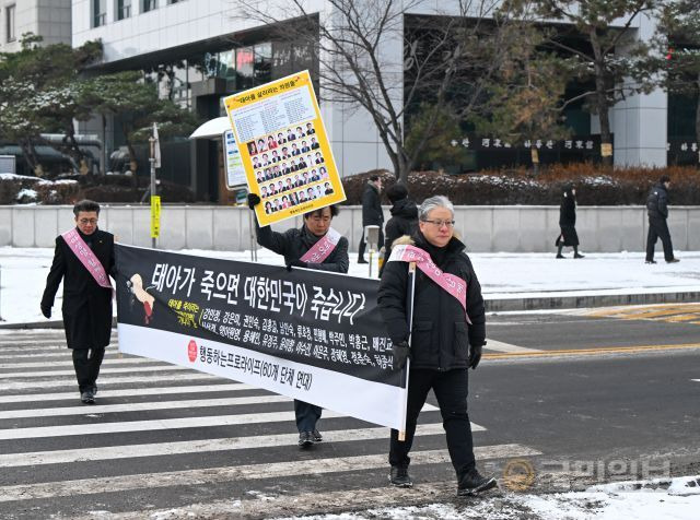 행동하는프로라이프 공동대표들이 20일 국회의원들의 이름이 적힌 현수막을 들고 횡단보도를 건너고 있다. 신석현 포토그래퍼