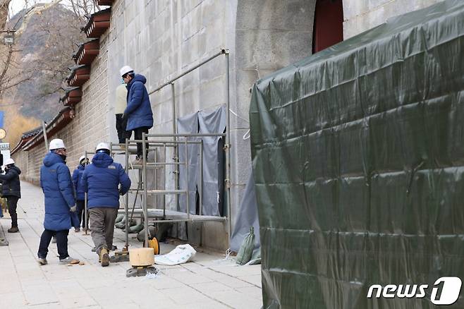 (서울=뉴스1) 박정호 기자 = 경복궁 담벼락 '낙서 테러'가 이틀째 이어진 18일 오전 서울 종로구 통의동 경복궁 영추문 앞에서 문화재청 관계자들이 복구 작업을 위해 가림막 설치 작업을 하고 있다. 2023.12.18/뉴스1  Copyright (C) 뉴스1. All rights reserved. 무단 전재 및 재배포,  AI학습 이용 금지.