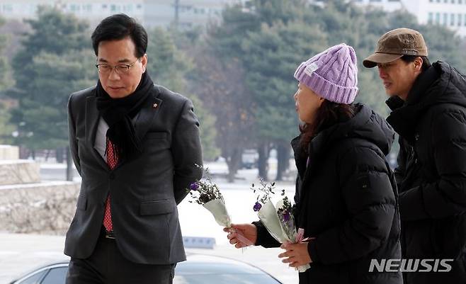 [서울=뉴시스] 조성봉 기자 = 송언석 국민의힘 의원이 20일 오후 서울 여의도 국회 본청 입구에서 '이태원참사 특별법 국회 본회의 통과'를 촉구하며 보라색 꽃다발을 나눠주는 이태원참사 유가족을 지나쳐가고 있다. 2023.12.20. suncho21@newsis.com