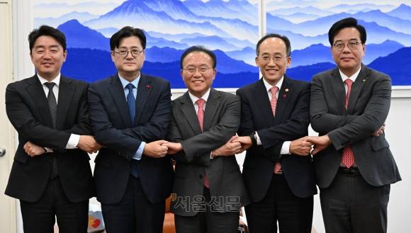 윤재옥 국민의힘 원내대표와 홍익표 더불어민주당 원내대표가 20일 국회에서 2024년도 예산안 처리를 위한 합의를 마친 뒤 손을 맞잡고 있다. 왼쪽부터 강훈식 더불어민주당 예결위 간사, 홍 원내대표, 윤 원내대표, 추경호 경제부총리 겸 기획재정부 장관, 송언석 국민의힘 예결위 간사. 2023.12.20 홍윤기 기자