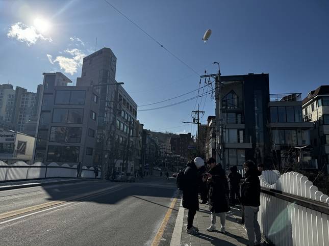 20여명의 이용자들이 21일 오전에 진행된 비행선 시위를 지켜봤다./사진=비즈워치