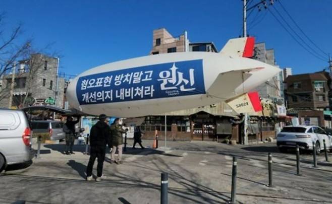 21일 서울 마포구 홍대입구역 인근에서 온라인 게임 ‘원신’ 관련 개발사 호요버스 비판 공중 시위에 사용되는 비행선의 모습. [사진출처=연합뉴스]