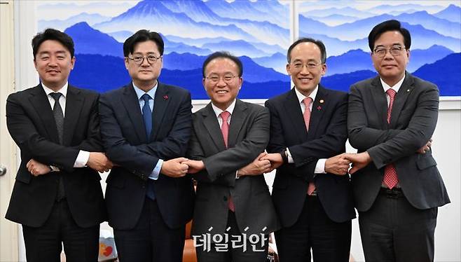 윤재옥 국민의힘 원내대표와 홍익표 더불어민주당 원내대표가 20일 국회에서 2024년도 예산안 처리를 위한 합의를 마친 뒤 손을 맞잡고 있다. 왼쪽부터 강훈식 더불어민주당 예결위 간사, 홍 원내대표, 윤 원내대표, 추경호 경제부총리 겸 기획재정부 장관, 송언석 국민의힘 예결위 간사. ⓒ데일리안 홍금표 기자