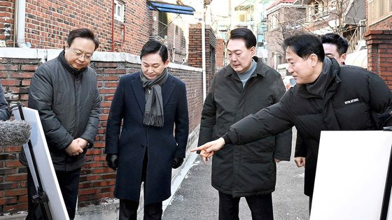 윤석열 대통령이 21일 서울 중랑구 모아타운 사업 지역에서 오세훈 서울시장의 사업설명을 듣고 있다. 사진 대통령실사진기자단