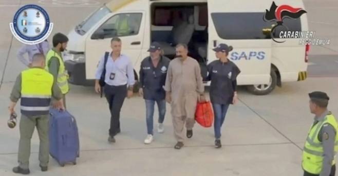 샤바르 압바스가 8월 31일(현지시간) 이탈리아 군사경찰 요원들에 이끌려 이탈리아로 송환되는 비행기에 오르기 위해 걸어가고 있다. 이탈리아 군사경찰 동영상 캡처 