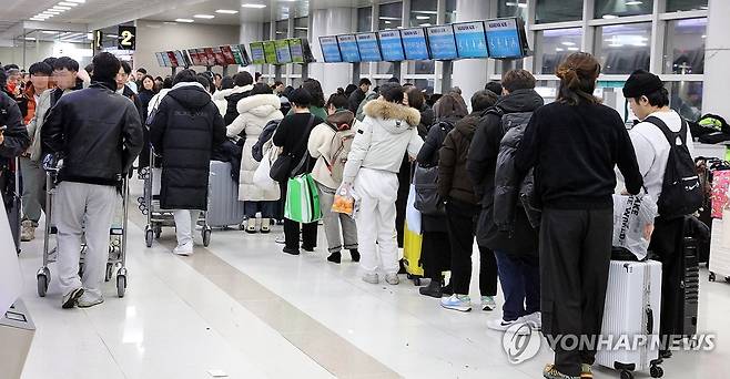 제주공항 결항편 이용객 예약 변경 대기 줄 (제주=연합뉴스) 김호천 기자 = 21일 오후 제주공항에 폭설과 강풍이 불면서 항공편이 무더기로 결항한 가운데 이용객들이 항공편 변경을 위해 줄을 서서 기다리고 있다. 2023.12.21 khc@yna.co.kr