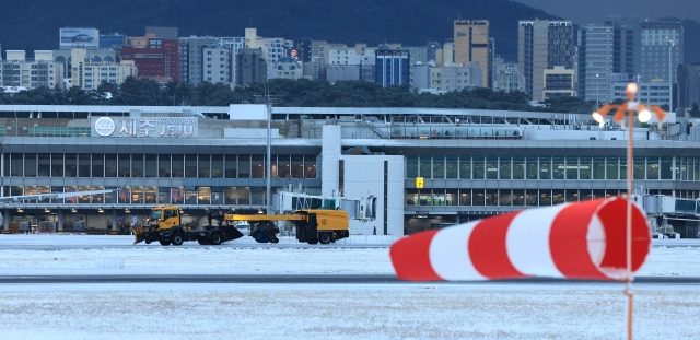 북극발 한파가 몰아친 21일 오후 제주국제공항 활주로에서 한국공항공사 제설차량이 눈을 치우고 있다. 연합뉴스.