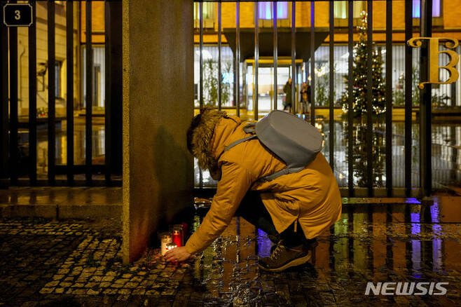 [프라하=AP/뉴시스] 21일(현지시각) 체코 프라하의 카렐 대학교 철학과 건물 밖에서 한 여성이 총격 희생자를 애도하는 촛불을 밝히고 있다. 체코 경찰은 이 학교에서 발생한 대규모 총격으로 최소 15명이 숨지고 24명이 다쳤다고 밝혔다. 총격범은 24세의 데이비드 코자르라는 이 학교 학생으로 경찰과 대치 중 지붕에서 떨어져 숨진 것으로 알려졌다. 2023.12.22.