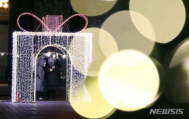 [서울=뉴시스] 최진석 기자 = 22일 서울 광진구 뚝섬한강공원에 열린 2023 로맨틱 한강 크리스마스 마켓을 찾은 시민들이 기념촬영 후 사진을 보고 있다. 2023.12.22. myjs@newsis.com