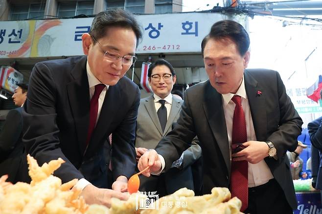 윤석열 대통령이 12월 6일 부산 부평깡통시장의 한 분식점 앞에서 이재용 삼성전자 회장에게 어묵 국물을 따라주고 있다. 대통령실 제공