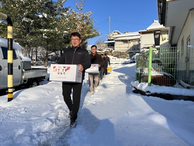 남군산교회 성도들이 지난 21일 전북 군산 소외 이웃에게 성탄 선물을 전달하기 위해 눈이 쌓인 길을 걸어가고 있다.