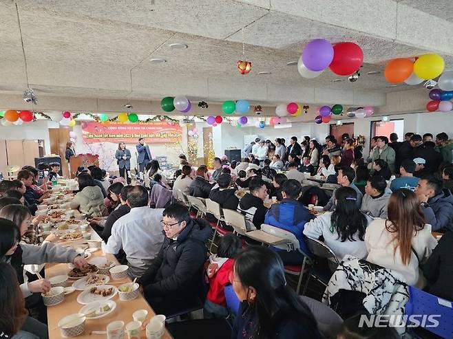 [창원=뉴시스]홍정명 기자=24일 낮 경남이주민센터에서 경남베트남교민회 주관 '외국인주민을 위한 자국음식잔치-반가운 친구, 그리운 집밥' 행사에 참석한 베트남 이주민들이 설날 음식을 먹으며 즐거운 시간을 보내고 있다.(사진=경남이주민센터 제공) 2023.12.24. photo@newsis.com