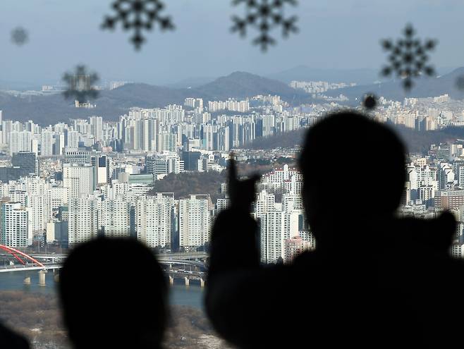 지난 21일 오전 서울 여의도 63스퀘어 전망대 63아트를 찾은 관람객들이 도심 아파트 단지를 바라보고 있다. /뉴스1