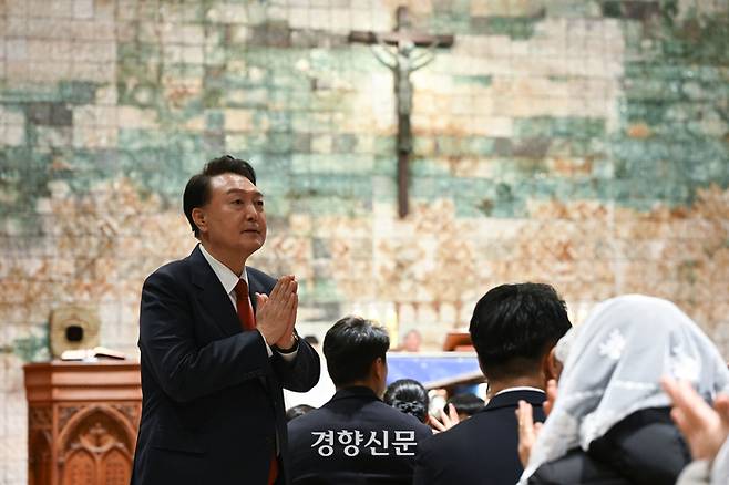 윤석열 대통령이 지난 24일 밤 서울 혜화동 성당에서 열린 성탄대축일 미사에 참석해 주임신부의 소개에 따라 신도들에게 인사하고 있다. 대통령실 제공