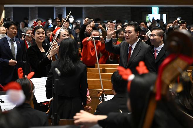 윤석열 대통령이 성탄절인 25일 서울 중구 정동제일교회에서 열린 성탄 예배에서 오케스트라 공연단을 격려하고 있다. [연합]