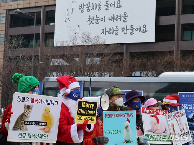 [서울=뉴시스] 김명원 기자 = 한국채식연합, 한국비건협회 회원들이 25일 서울 종로구 이순신동상 앞에서 인간과 동물 그리고 지구가 행복한 비건 크리스마스를 위한 기자회견을 하고 있다. 2023.12.25. kmx1105@newsis.com