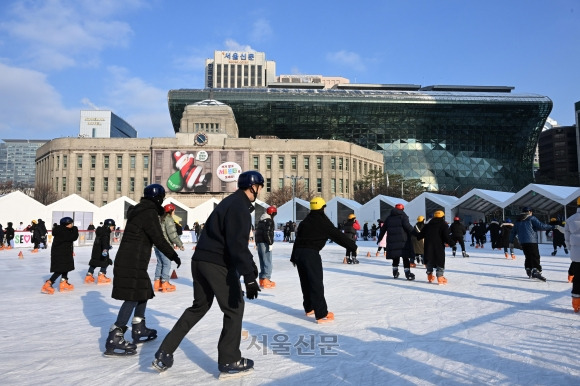 ‘눈꽃 얼음’ 즐거운 서울광장 - 성탄절을 하루 앞둔 24일 서울 중구 서울광장 스케이트장을 찾은 시민들이 눈 내린 풍경 속에서 스케이트를 즐기고 있다. 연휴인 25일 성탄절까지 눈 예보가 있어 서울 지역을 기준으로 8년 만의 ‘화이트 크리스마스’가 될 것으로 전망된다. 도준석 기자