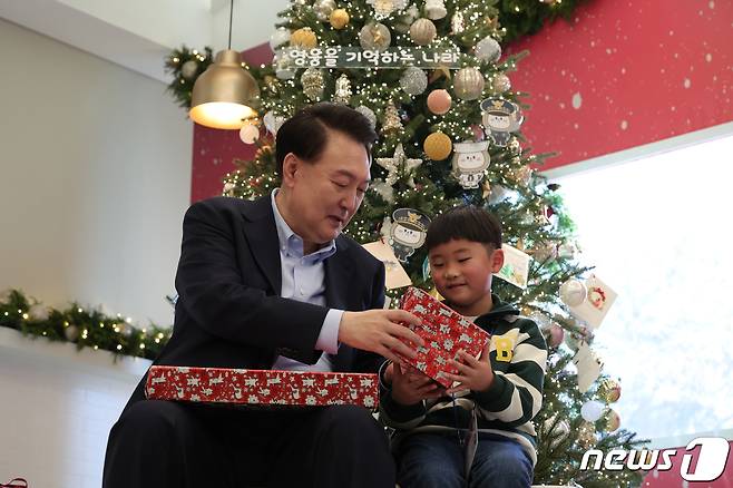 윤석열 대통령이 지난 22일 서울 용산구 대통령실 청사에서 열린 '히어로즈 패밀리와 함께하는 꿈과 희망의 크리스마스' 행사에 참석, 어린이들에게 선물을 전달하고 있다. (대통령실 제공) 2023.12.22/뉴스1 ⓒ News1 오대일 기자