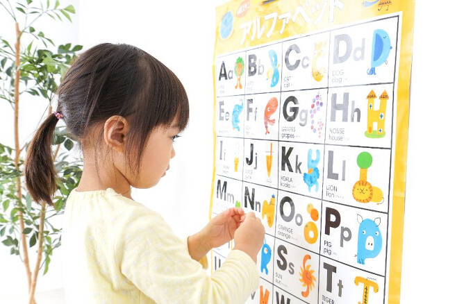 한 아이가 영어 알파벳 그림표를 바라보고 있다. [123RF]
