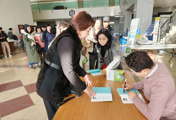 노관규 순천시장이 26일 순천대에서 출판기념회를 열고 자신의 책에 사인을 해주고 있다. [독자 제공]