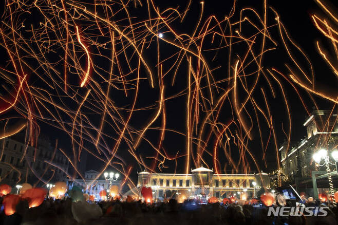 [아테네=AP/뉴시스] 24일(현지시각) 장노출로 찍은 사진에 그리스 아테네의 코지아 광장에서 크리스마스 기념행사가 열려 참가자들이 풍등을 날리고 있다. 2023.12.25.