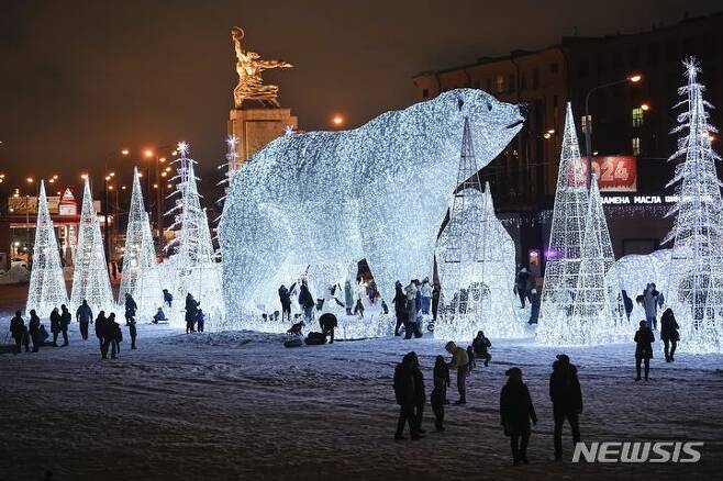[모스크바=AP/뉴시스] 러시아 유명 조각가 베라 무히나의 새해와 크리스마스 축하 스테인리스 작품이 설치된 모스크바의 한 공원에서 24일(현지시각) 시민들이 즐거운 시간을 보내고 있다. 2023.12.25.