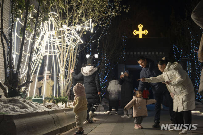 [베이징=AP/뉴시스] 25일 중국 베이징의 시스쿠교당을 찾은 방문객들이 크리스마스 조형물을 구경하고 있다. 2023.12.26.