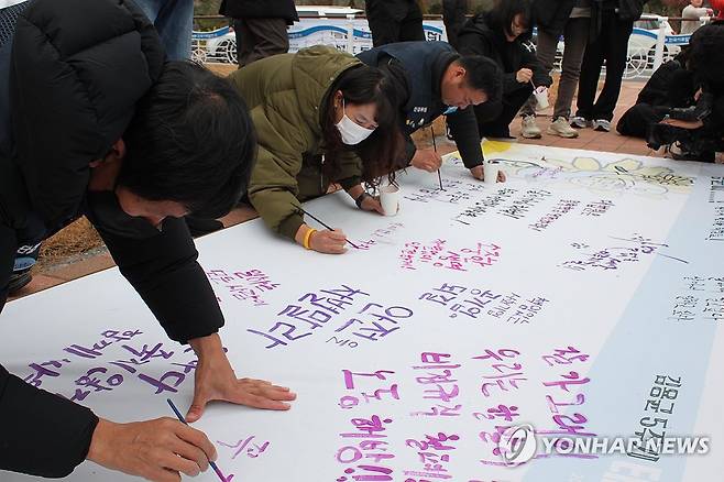 "안전을 차별말라" (태안=연합뉴스) 정윤덕 기자 = 2018년 충남 태안화력발전소에서 끼임 사고로 숨진 청년 비정규직 노동자 고(故) 김용균 씨 5주기 현장추모제가 열린 6일 추모객들이 작업 현장 안전과 중대재해처벌법 확대 적용 등을 촉구하는 글을 적고 있다. 2023.12.6 cobra@yna.co.kr