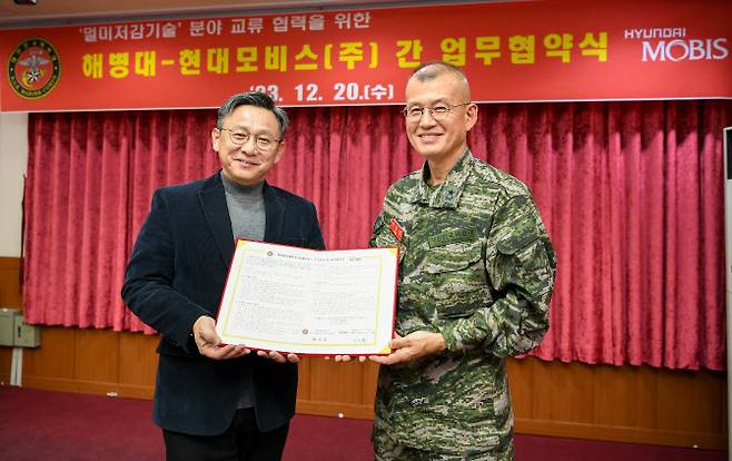 이승환 현대모비스 선행연구섹터장(왼쪽)과 박승일 해병대사령부 전력기획실장 ‘멀미저감 기술분야 협력’을 위한 협약식에서 기념촬영을 하고 있다. (사진=현대모비스)