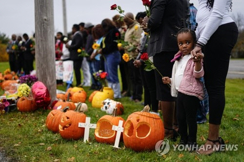 지난 10월 29일(현지시간) 총기 난사 사건이 발생한 메인주 루이스턴의 한 볼링장 밖에서 사람들이 희생자들을 추모하며 기도하고 있다. 25일 한 남성이 이 지역 볼링장과 식당에서 총기를 난사해 18명이 숨지고 13명이 다쳤다. (루이스턴[美메인주] AP=연합뉴스)