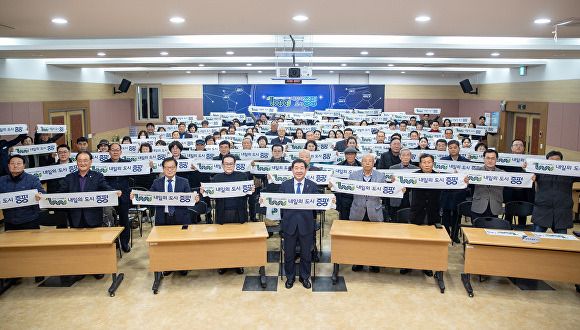 27일 공약사업 추진 현황 및 미래 비전 보고회 참석자들이 '새로운 미래 100년, 내일의 도시 증평'이라고 적힌 카드 섹션을 펼치고 있다. [사진=증평군]