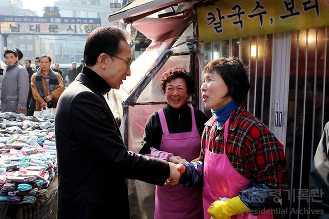 이명박 전 대통령이 지난 2011년 서울 남대문시장을 방문해 상인들의 이야기를 듣고 있다. 대통령기록관 제공