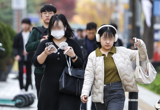 늦가을이라는 계절이 무색하게 더운 날씨를 보였던 지난달 2일 서울 종로구 세종대로 인근에서 한 시민이 손선풍기를 들고 이동하고 있다. 뉴시스