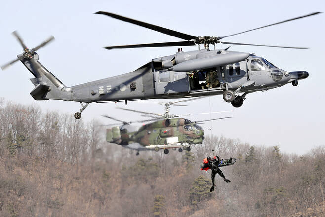 공군 HH-60 헬기가 조난당한 조종사를 구조하는 훈련에 참가, 구조대원과 조종사를 끌어올리고 있다. 세계일보 자료사진