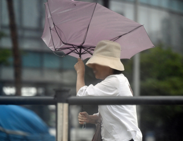 제6호 태풍 '카눈'이 한반도에 상륙한 지난 8월10일 서울 서대문역 사거리에서 한 시민이 우산을 꽉 붙잡고 있다. 성형주 기자