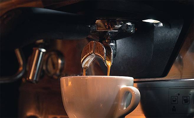 커피 가루에 고온 고압의 물을 통과시켜 에스프레소 커피를 추출하는 모습. 원두를 갈 때 물을 소량 추가하면 커피를 덜 쓰고도 균일한 맛을 낼 수 있다는 사실이 밝혀졌다. 사진 픽사베이