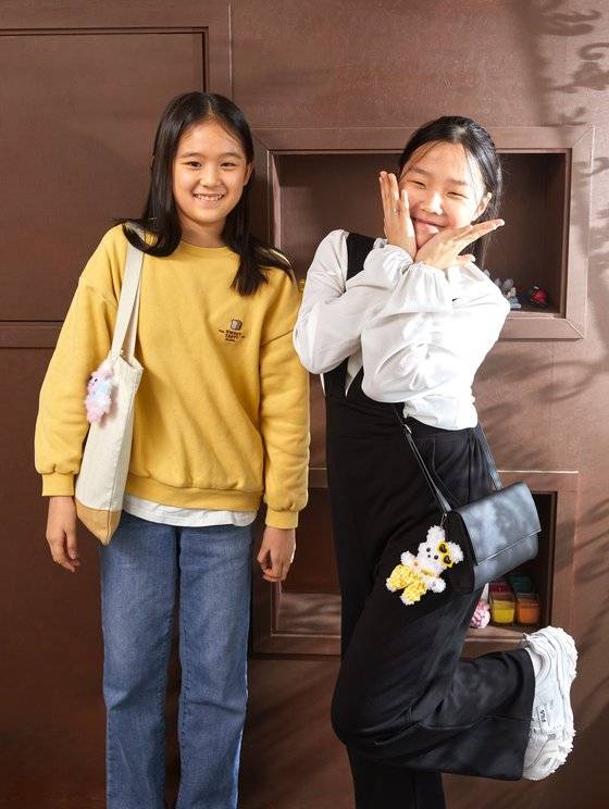 모루 공예에 대해 알아본 이유민(왼쪽)·정아인 학생기자가 최근 선풍적인 인기를 끌고 있는 모루 인형 키링을 직접 만든 후 가방에 달고 포즈를 취했다.