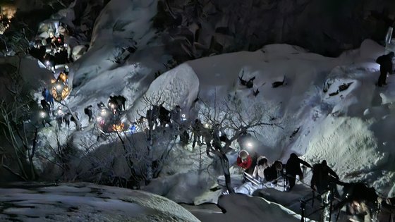 1일 오전 6시 30분쯤 서울 강북구 북한산 둘레길에 등산객들이 일출을 보기 위해 줄지어 산을 오르고 있다. 어두운 길을 밝히기 위해 저마다 랜턴을 키고 올라오는 모습이다. 장서윤 기자