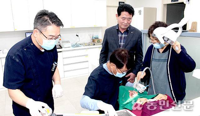 곽점용 전북 장수 장계농협 조합장(오른쪽 두번째)이 장계의료복지 사회적협동조합인 ‘우리치과’에서 최병환 원장(〃세번째)에게 치료받고 있는 조합원을 지켜보고 있다.
