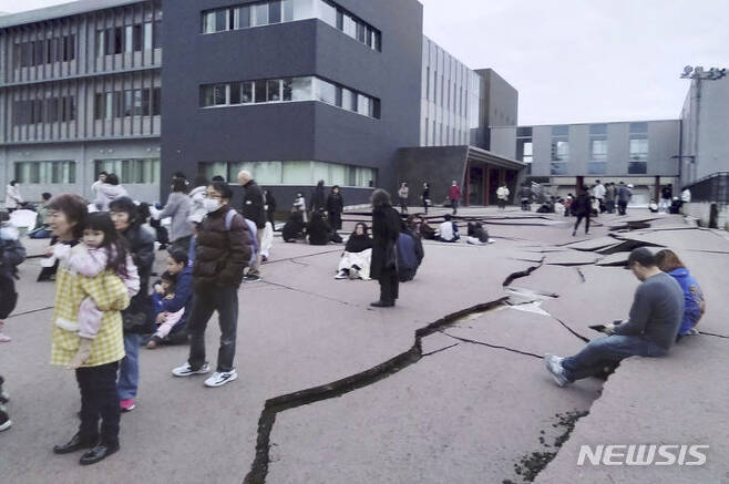 [와지마=AP/뉴시스] 1일 강진 발생 직후 일본 이시카와현 와지마시에서 주민들이 건물 밖으로 피한 가운데 거리의 아스팔트 길이 갈라져있다. 이날  일본 중부 동해 연안 이시카와현 노토(能登) 지역에서 규모 7.6 강진이 발생했다.